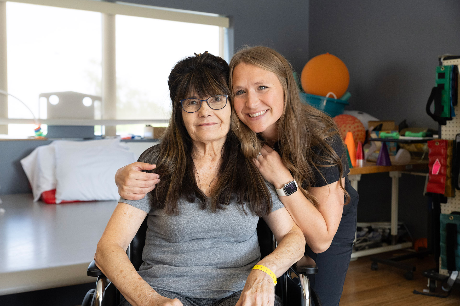 Two women smiling together in a playful environment.
