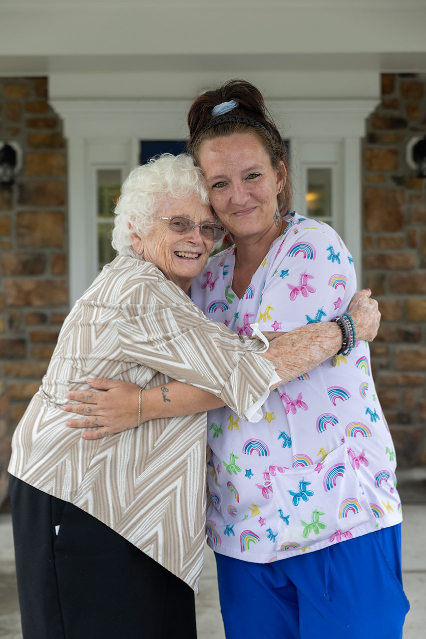 Two women embracing, showing joy and affection outside.