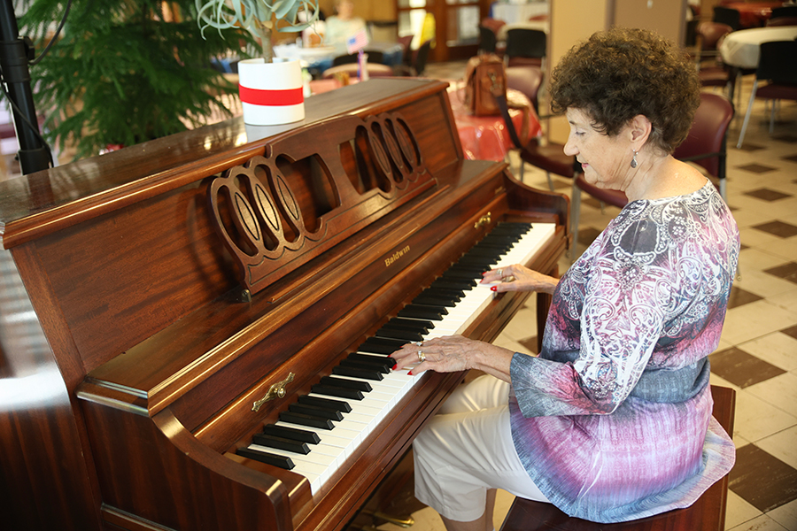 Woman playing piano in a cozy indoor setting.