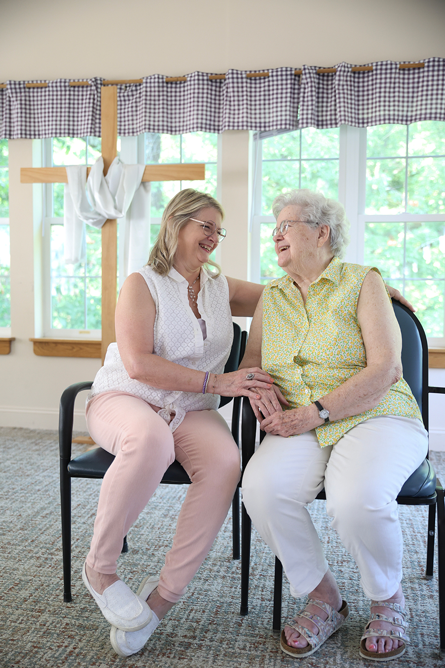 Two women sharing a joyful moment together in bright room.