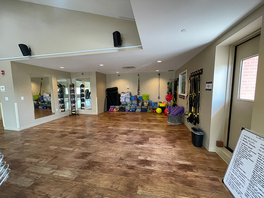 Fitness studio with exercise equipment and mirrors.