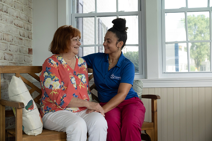Two women smiling and sharing a moment indoors.