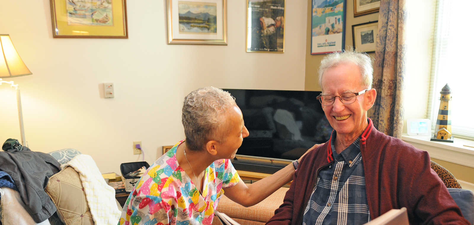 Two people share a joyful moment in a cozy room.