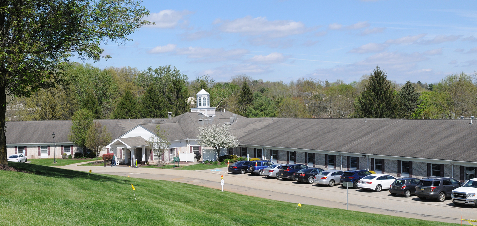 Single-story building with parking and green landscape.