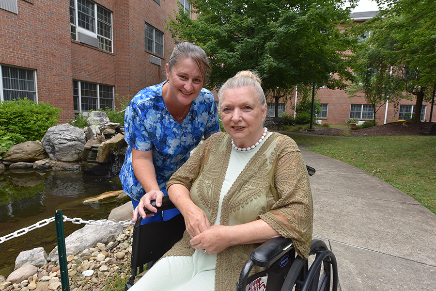 Two women enjoying time together in a flower garden.