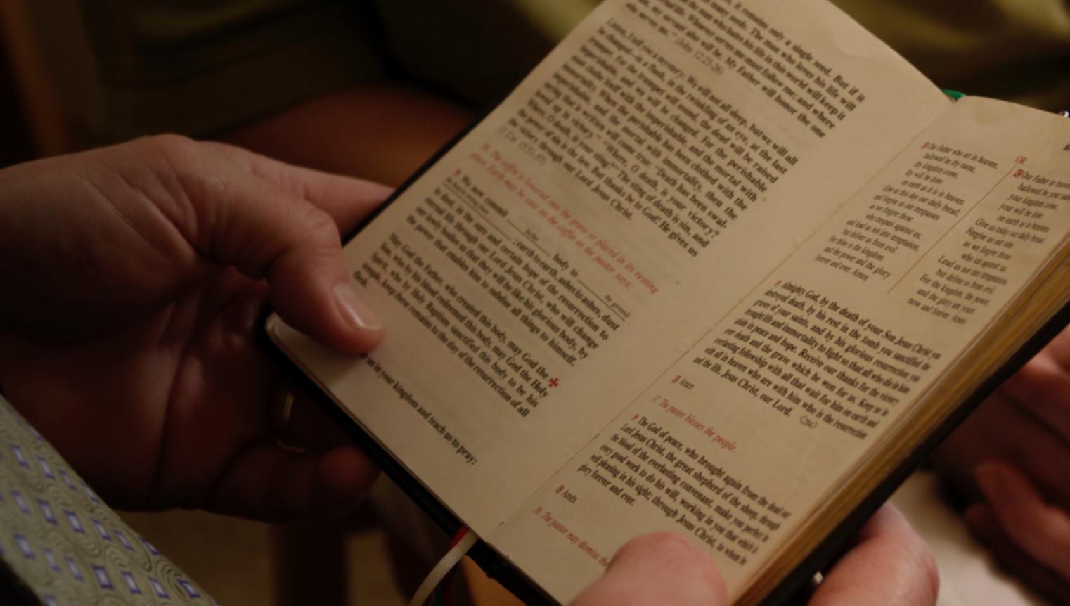 Hands holding open Bible
