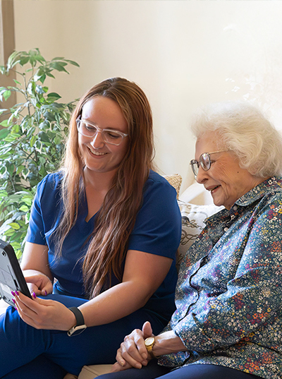 Nurse and patient engaging with a tablet together.