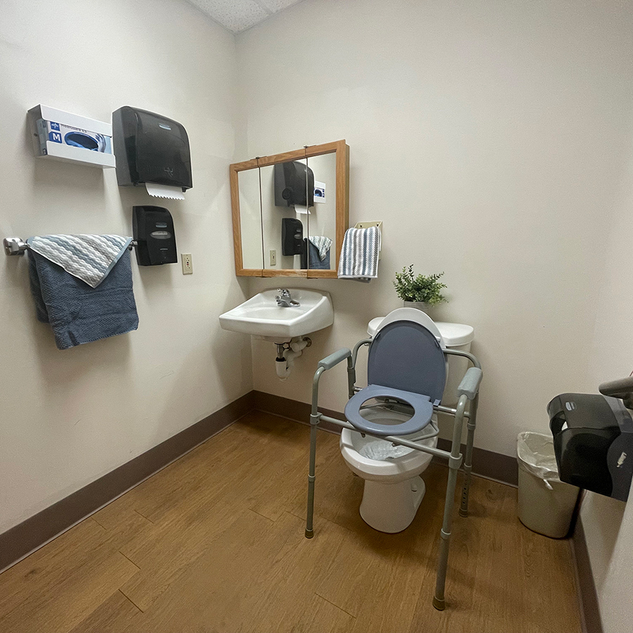 Clean bathroom with toilet, sink, and accessible features.