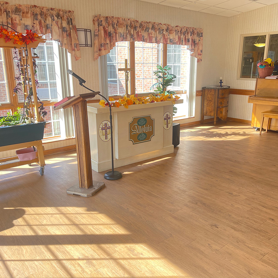 Bright interior with altar, plants, and musical instruments.