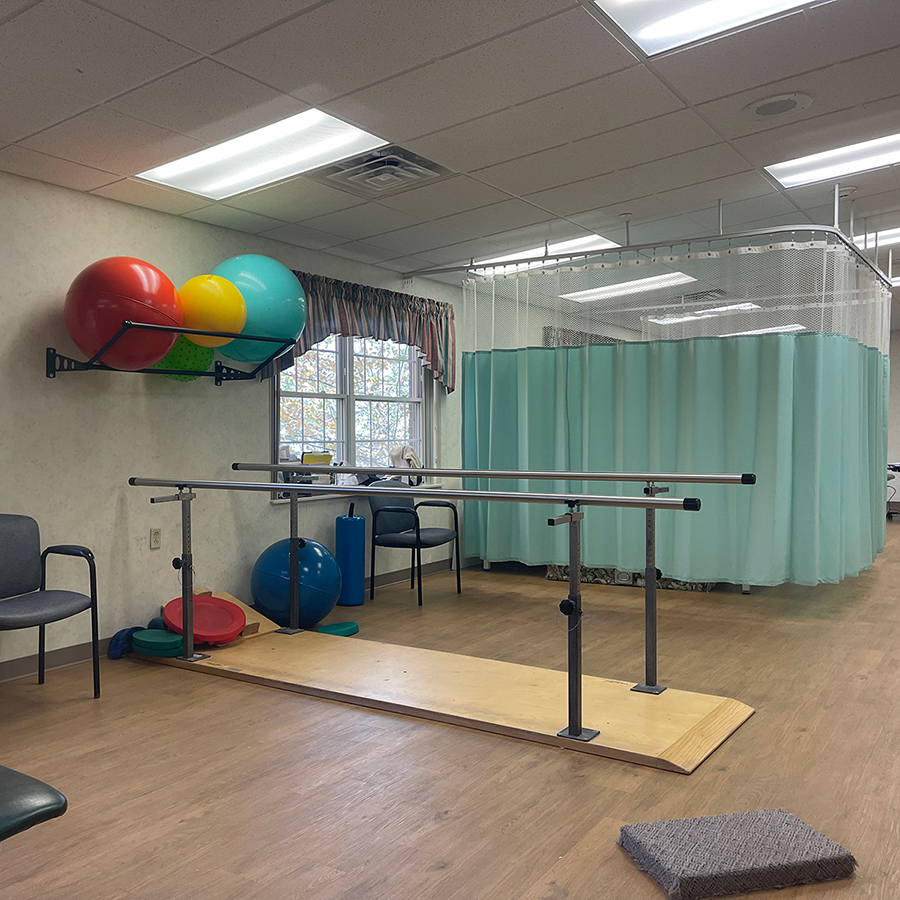 Physical therapy room with exercise equipment and colorful balls.