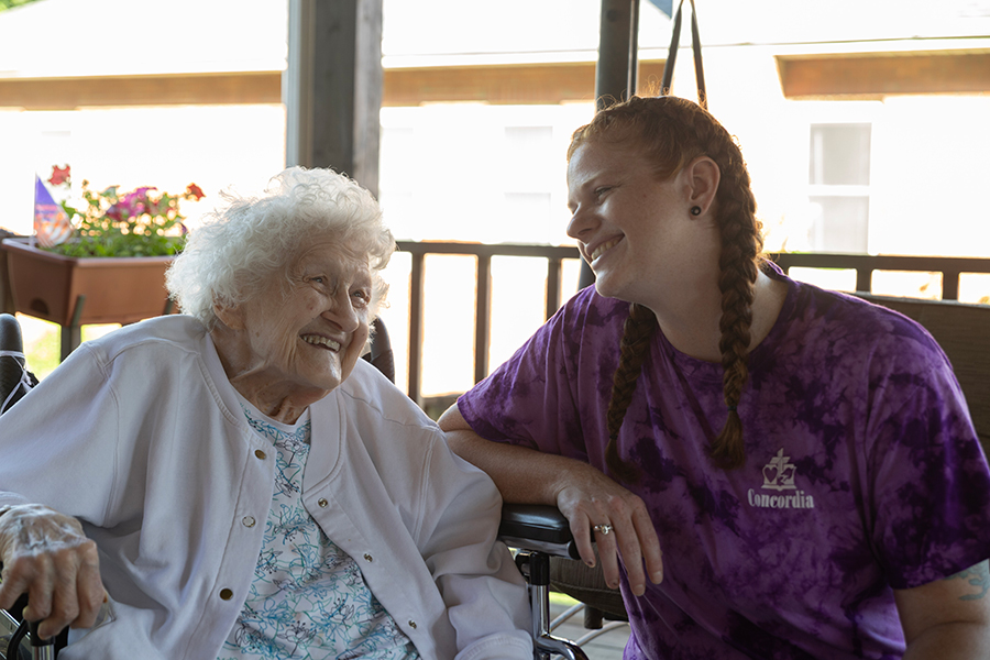 Two smiling women enjoying a cheerful conversation outside.