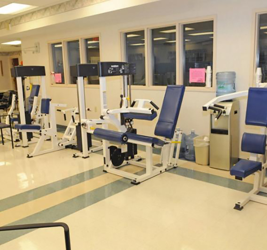 Gym with exercise machines and blue upholstery.