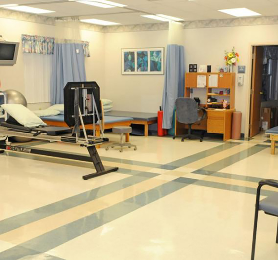 A clean, bright rehabilitation therapy room with equipment.