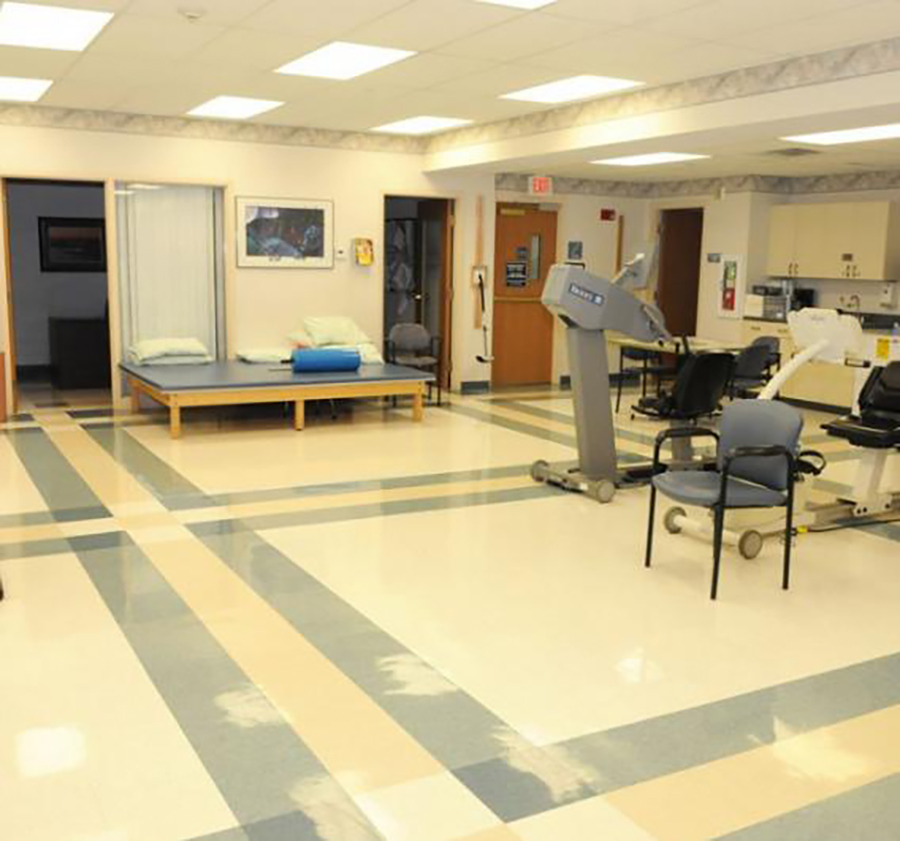 Bright, spacious therapy room with exercise equipment and seating.