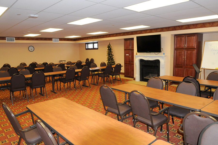 Conference room with tables, chairs, and a Christmas tree.