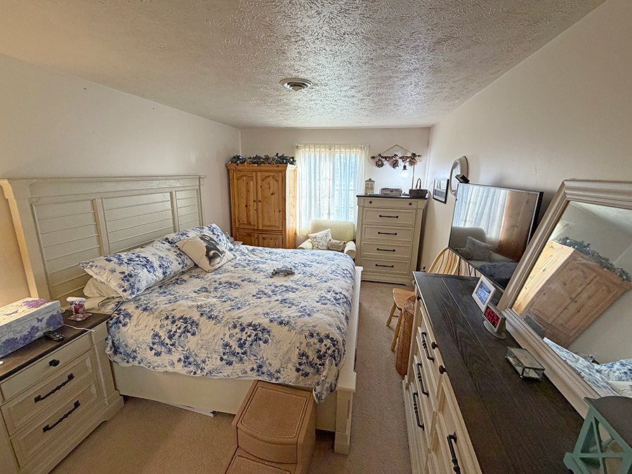 Cozy bedroom with floral bedding and natural light.