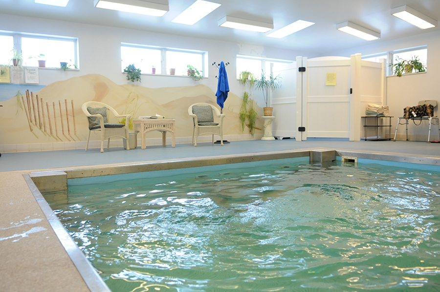 Indoor swimming pool with relaxing seating area and decor.