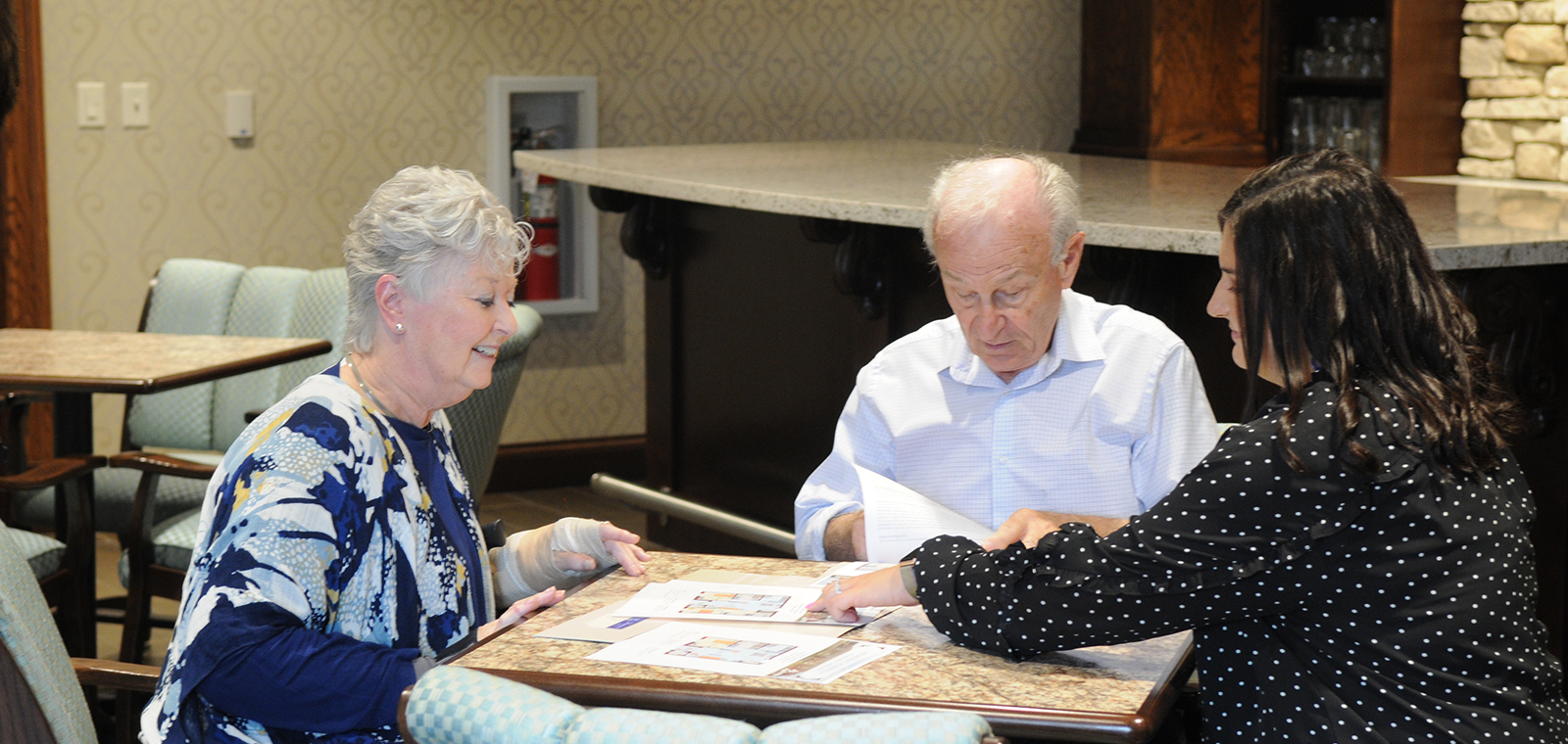 Three people engaged in discussion around a table.