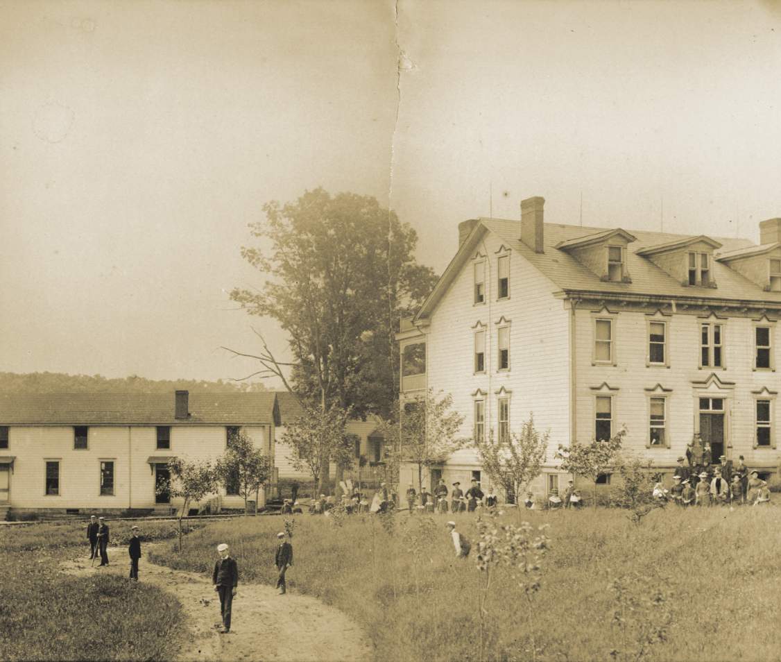 Historic buildings with people outside in a grassy area.