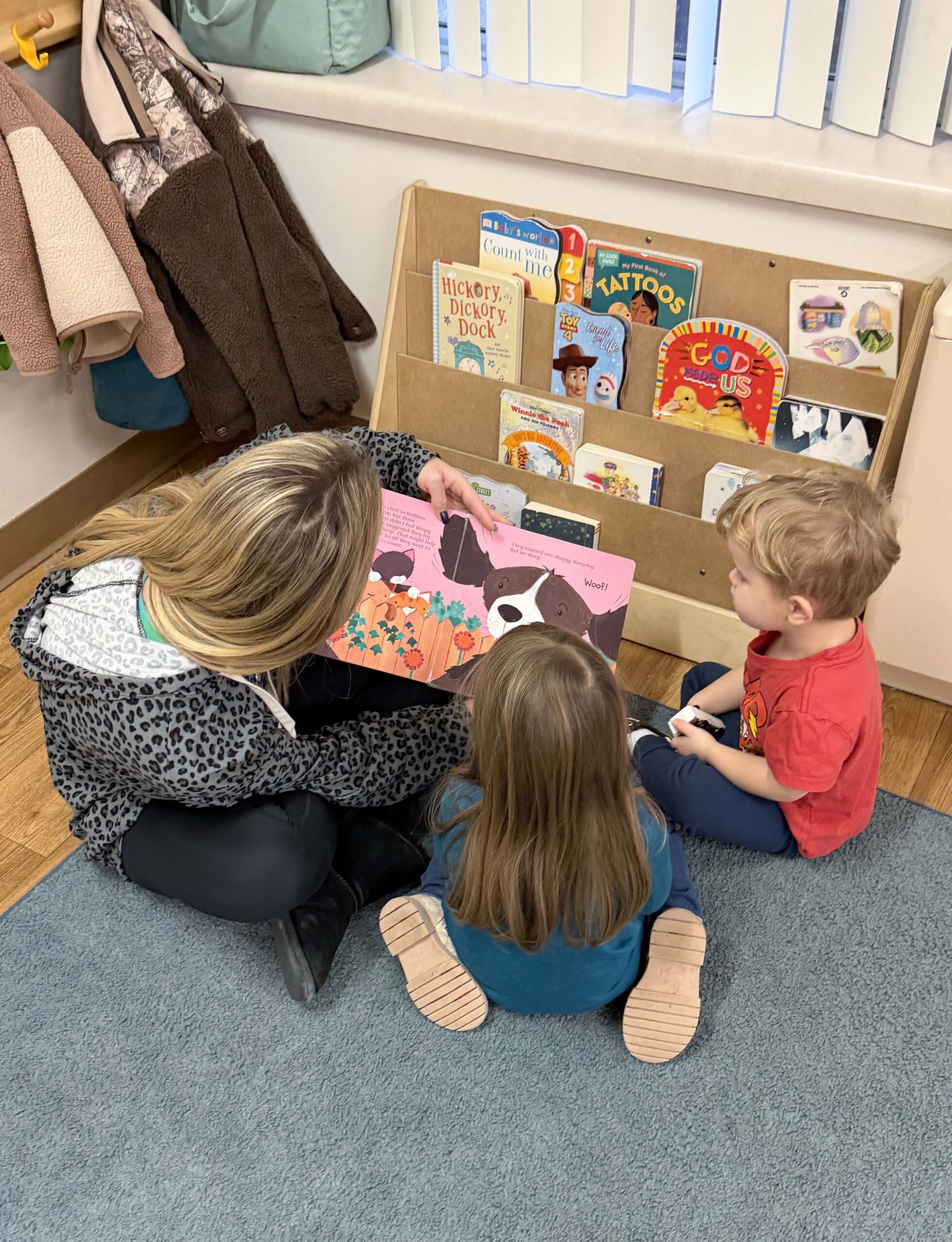 Children reading with an adult in a cozy setting.