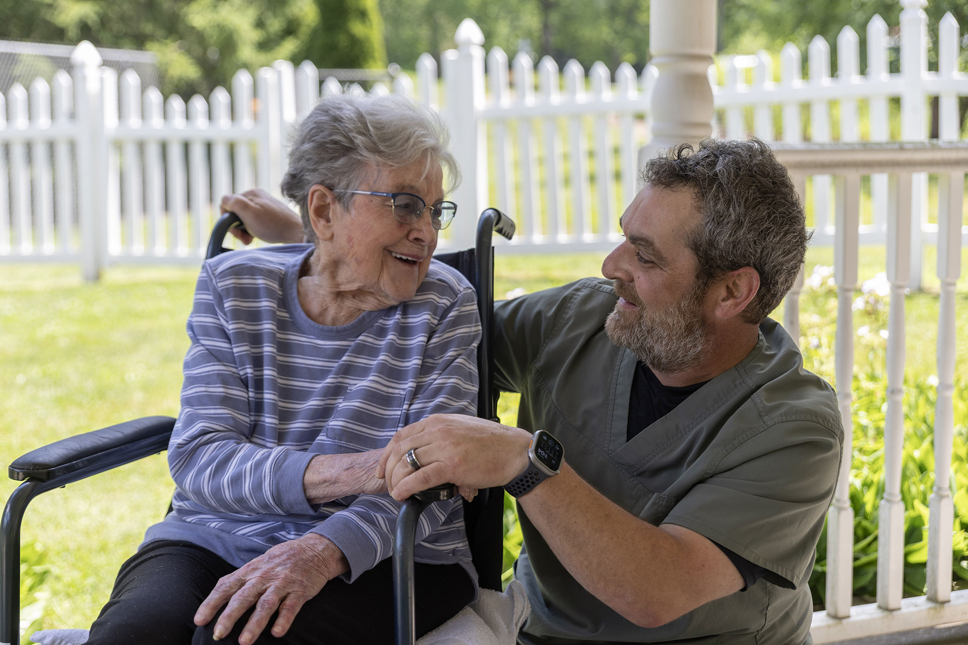 Older woman and caregiver sharing a warm, joyful moment.