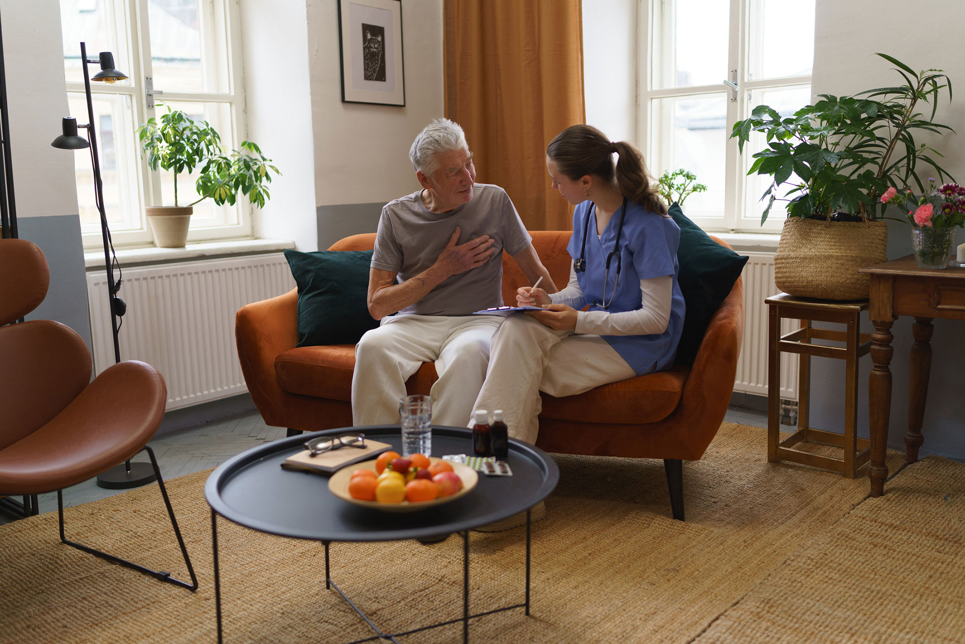 Caregiver discussing health with an elderly man in a cozy setting.