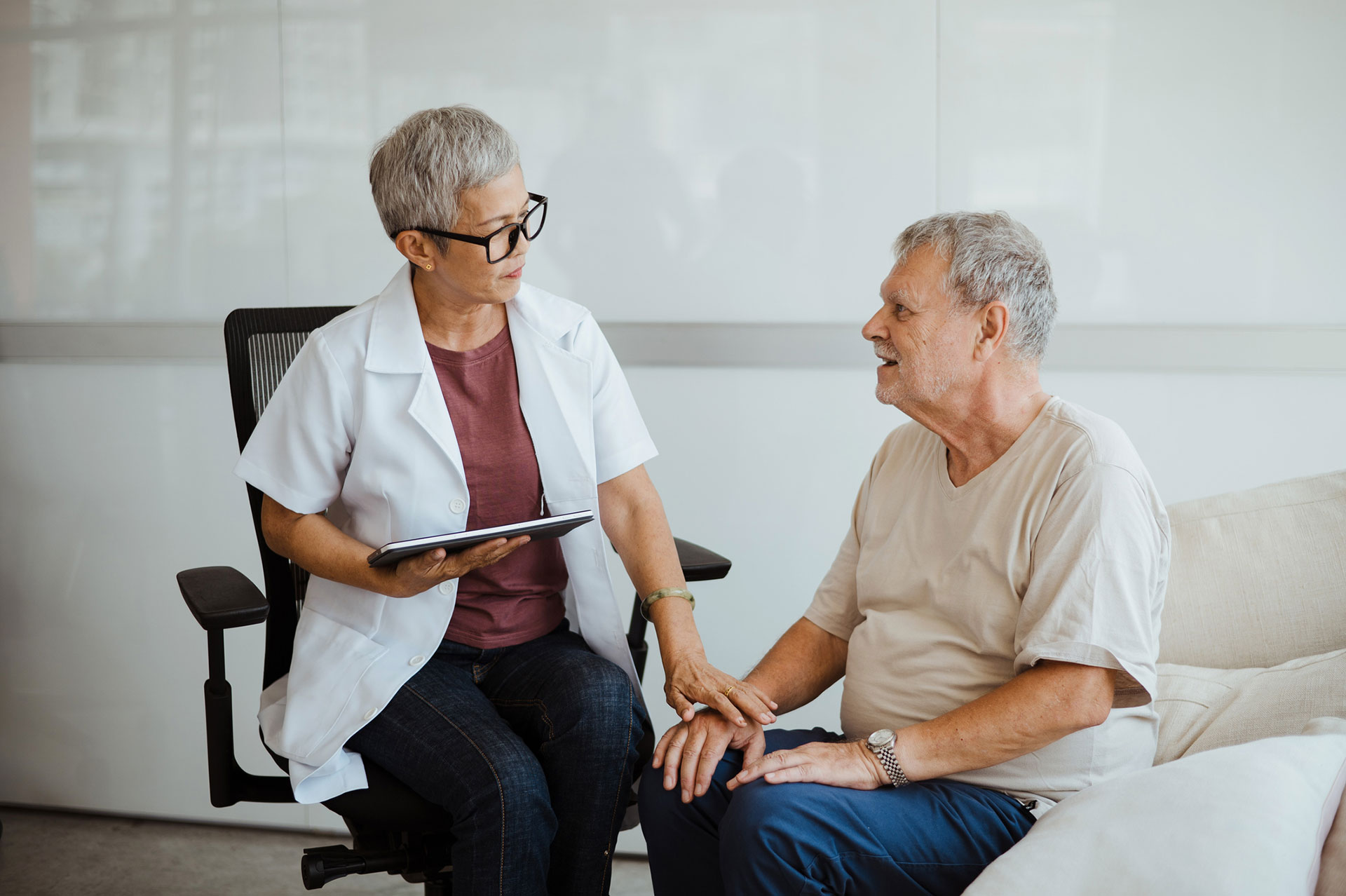Doctor consulting with senior patient in a comfortable setting.