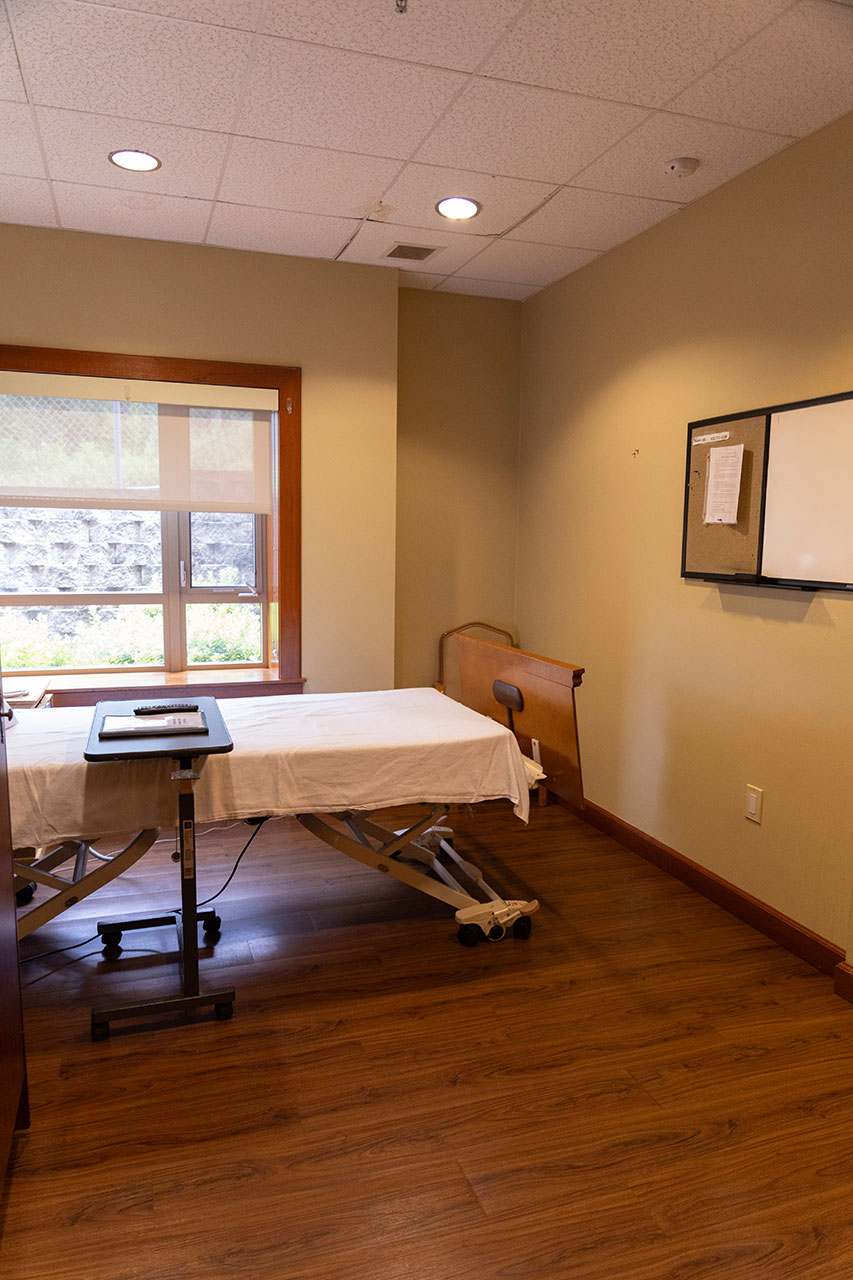 Therapy room with adjustable table and natural light.