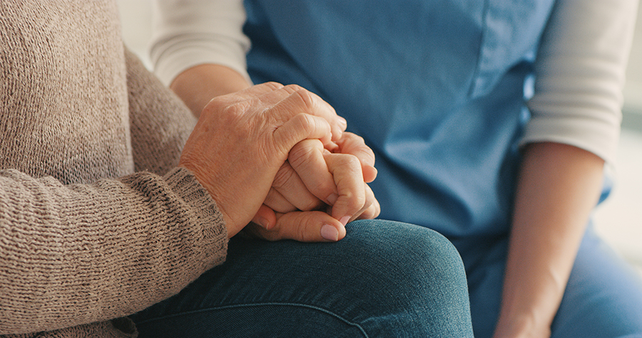 Two hands holding each other, symbolizing support and care.