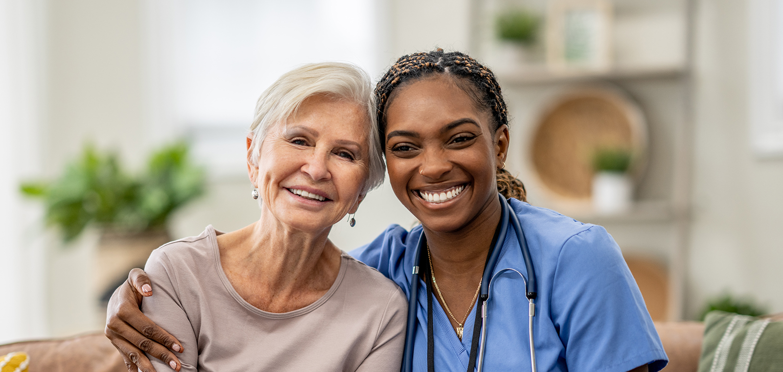 Smiling healthcare worker and elderly patient share joyful moment.
