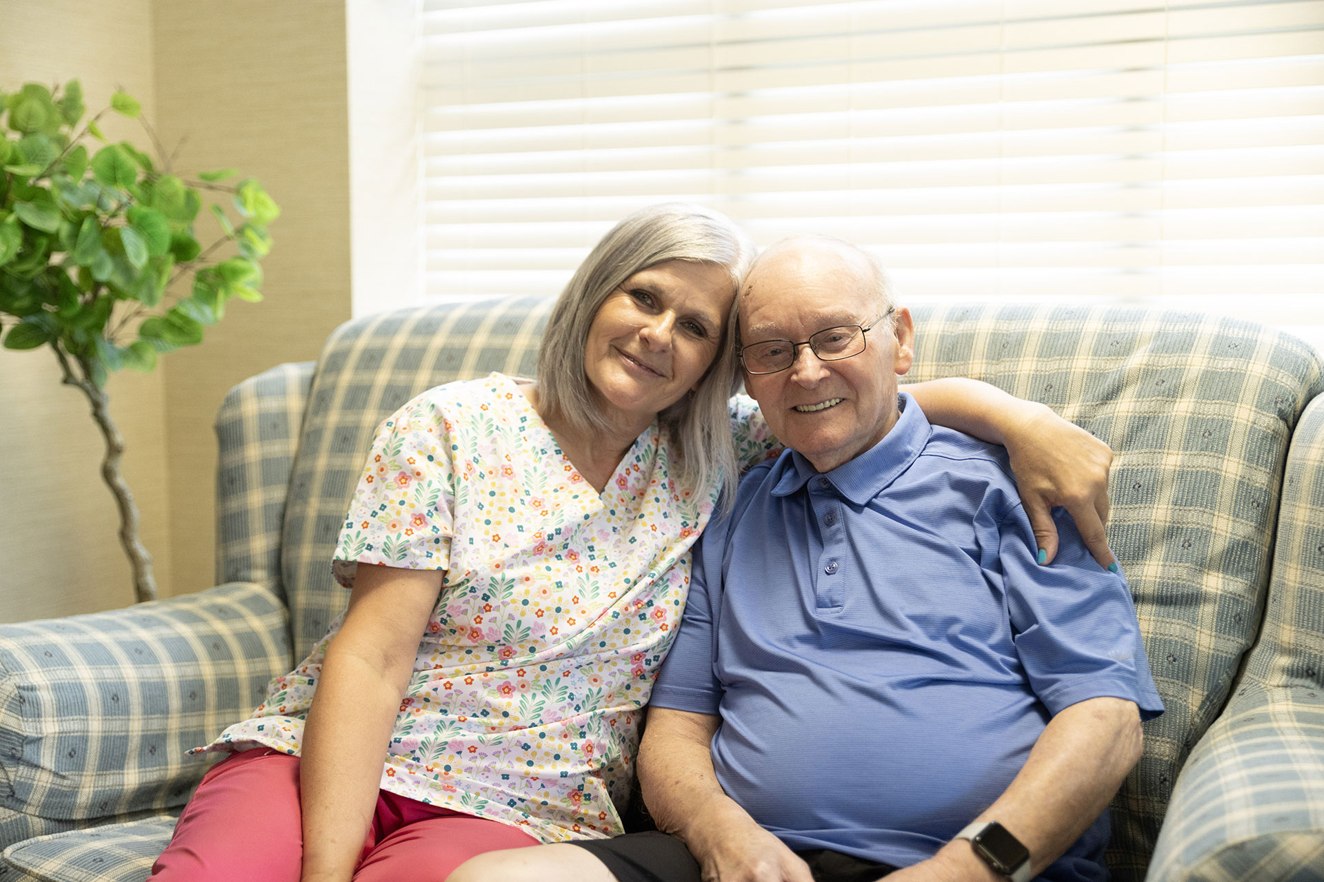 Smiling woman and man sitting together on a couch.