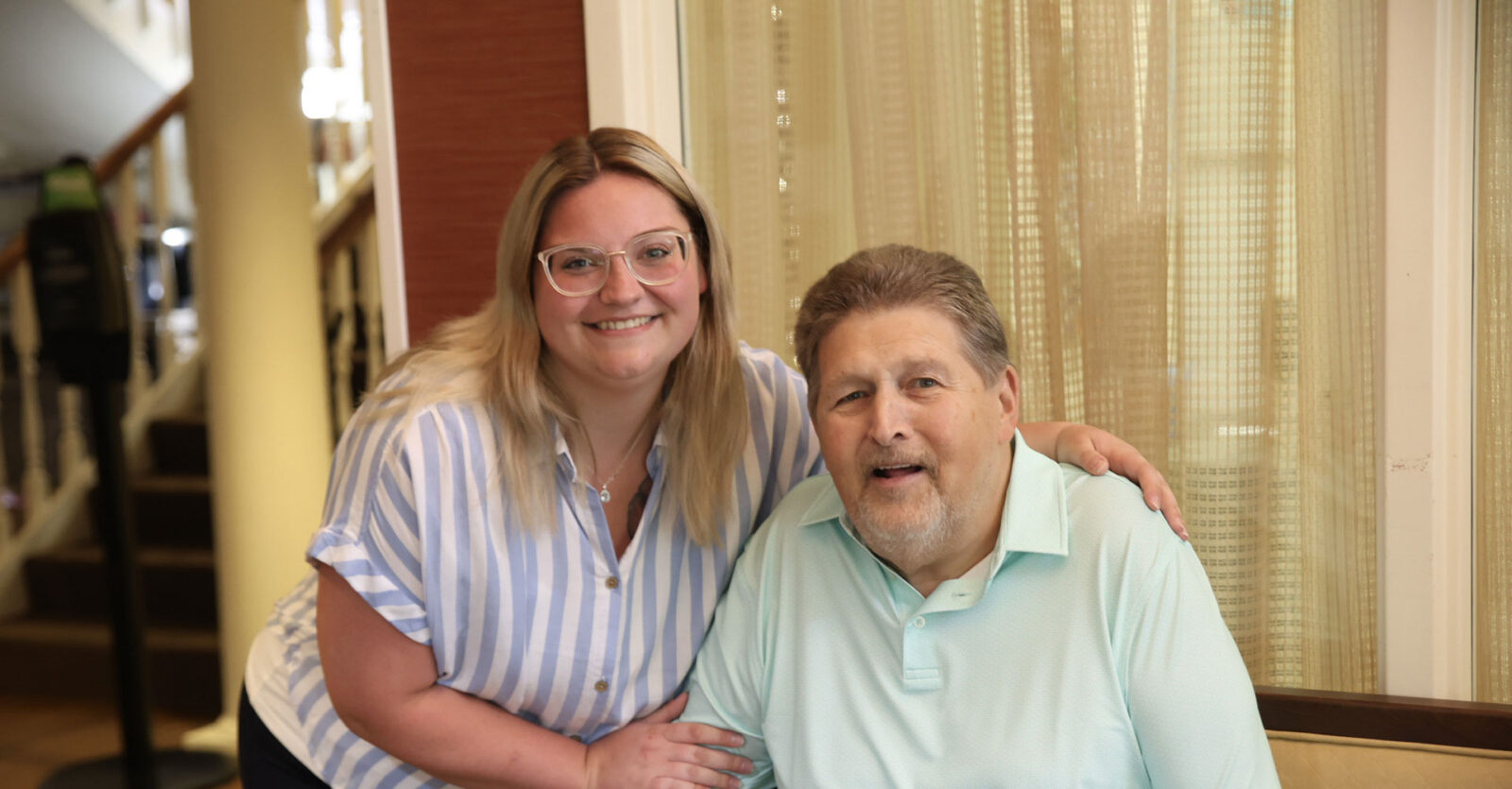 Woman and man smiling together, sitting indoors.