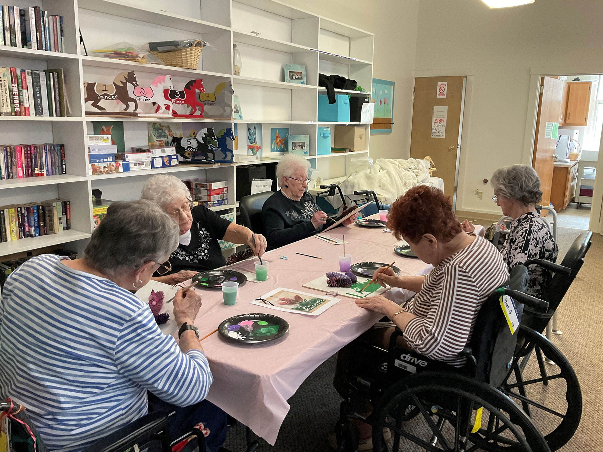 Seniors painting together in a community space.