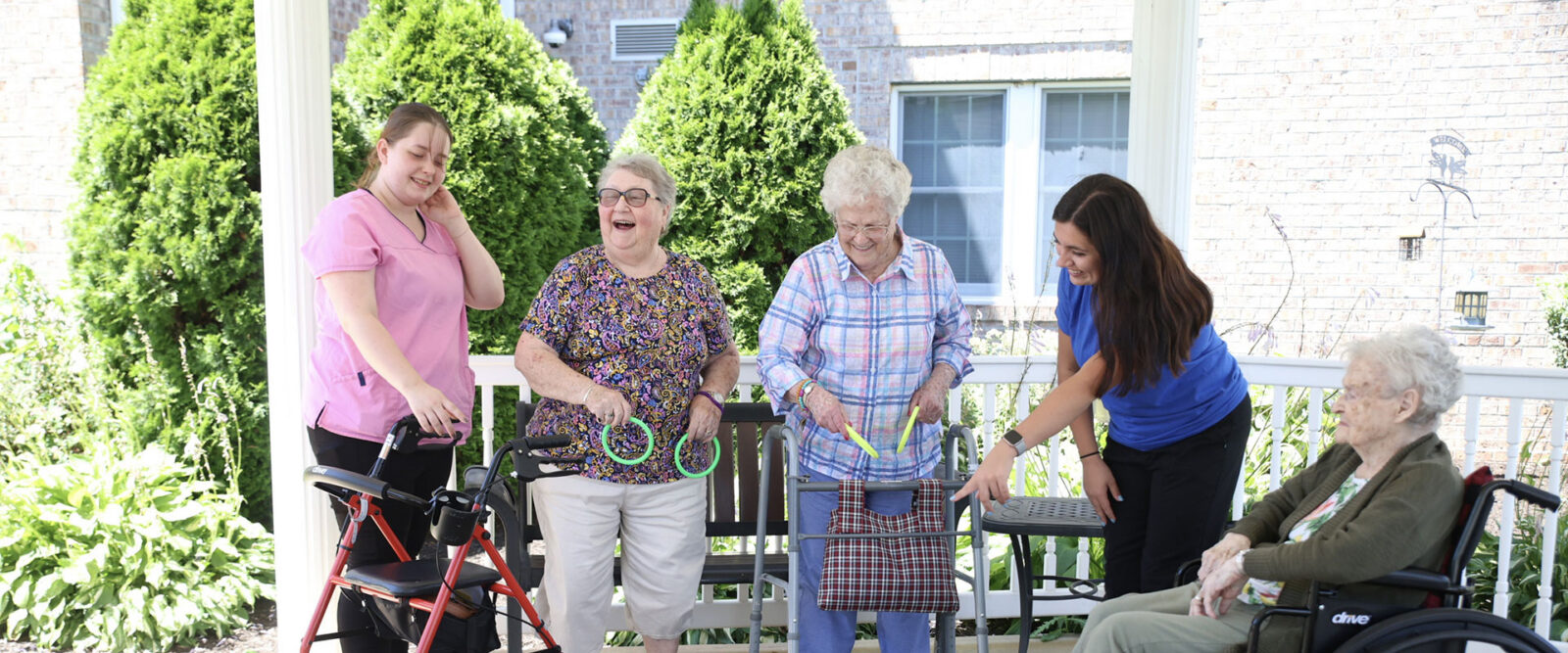 Elderly women and caregivers enjoying time outdoors together.