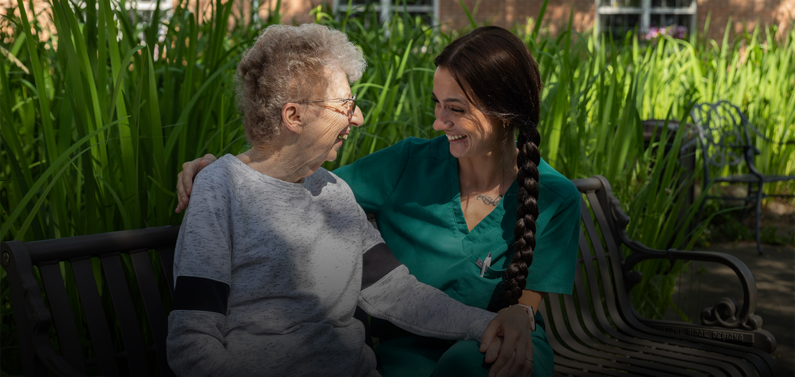 Two women enjoying time together in a flower garden.