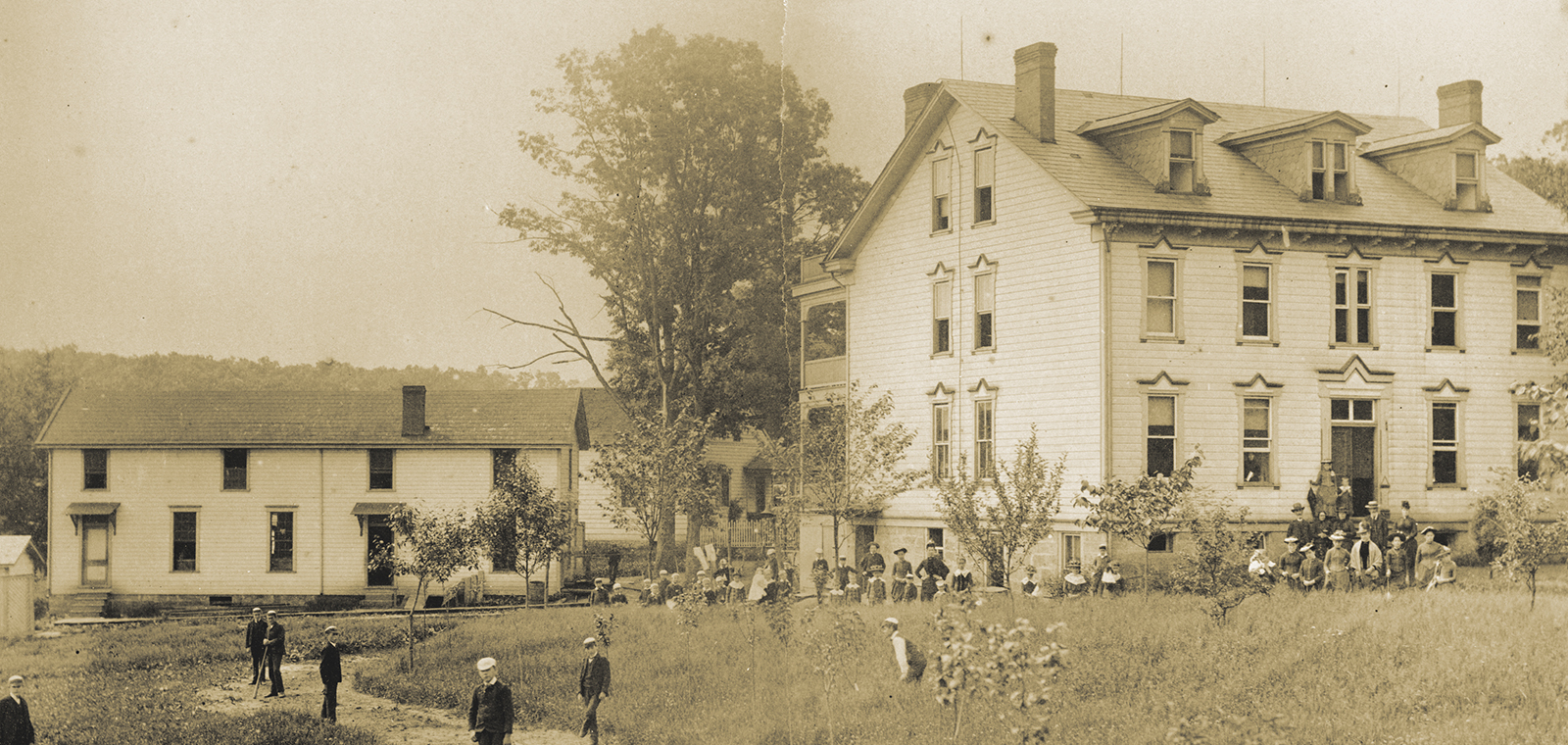 Historic building with people in a grassy area.