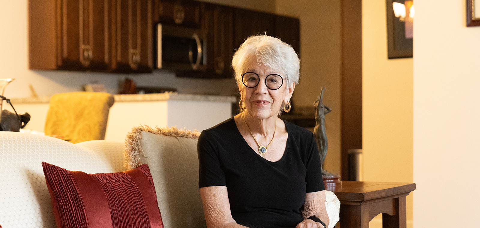 Elderly woman sitting comfortably in a cozy living room.
