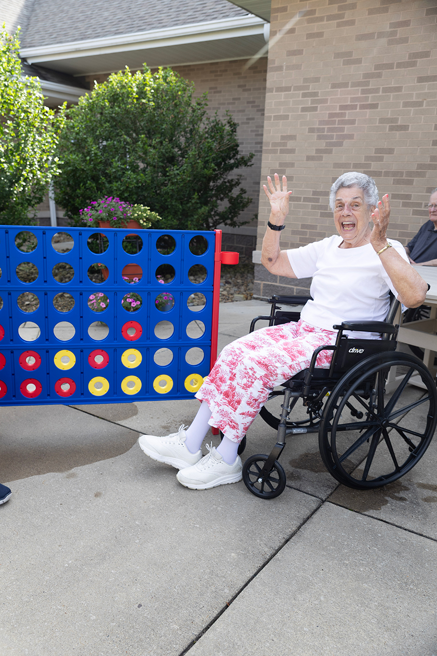 Elderly woman in wheelchair happily playing a large game.
