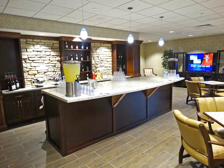 Modern lounge with bar, drinks, and seating area.