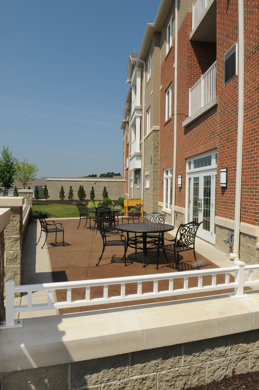 Patio area with metal tables and chairs near a building.