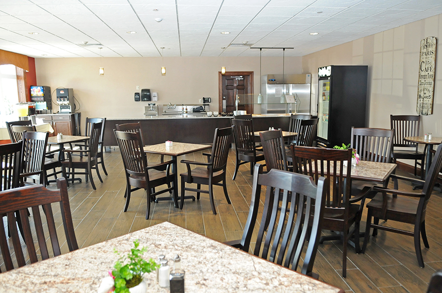 Spacious, modern dining area with wooden furniture and counter.