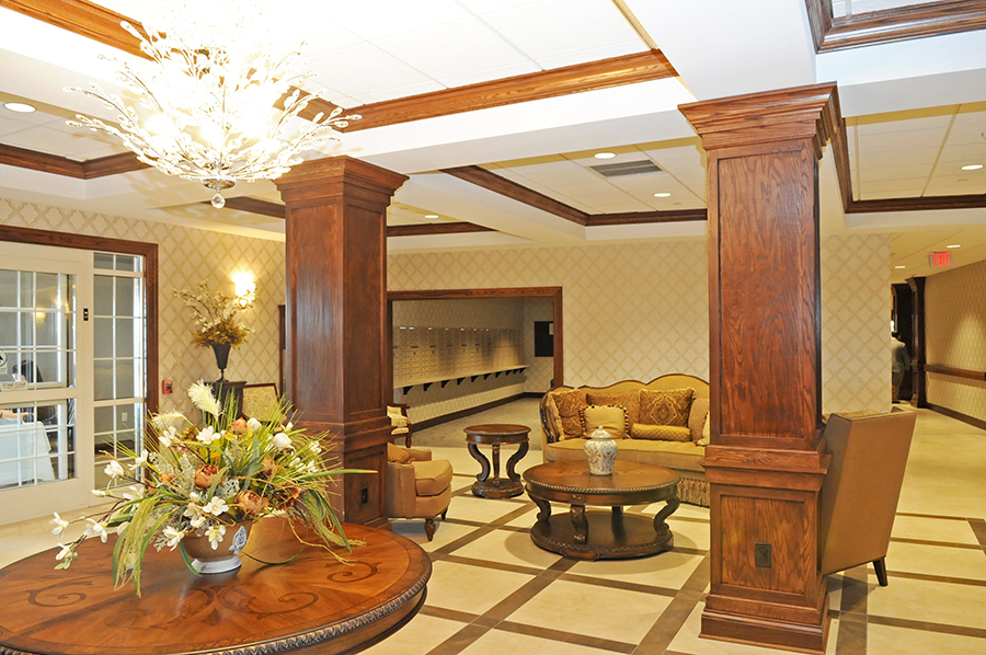 Elegant lobby with seating, decorative plants, and chandelier.
