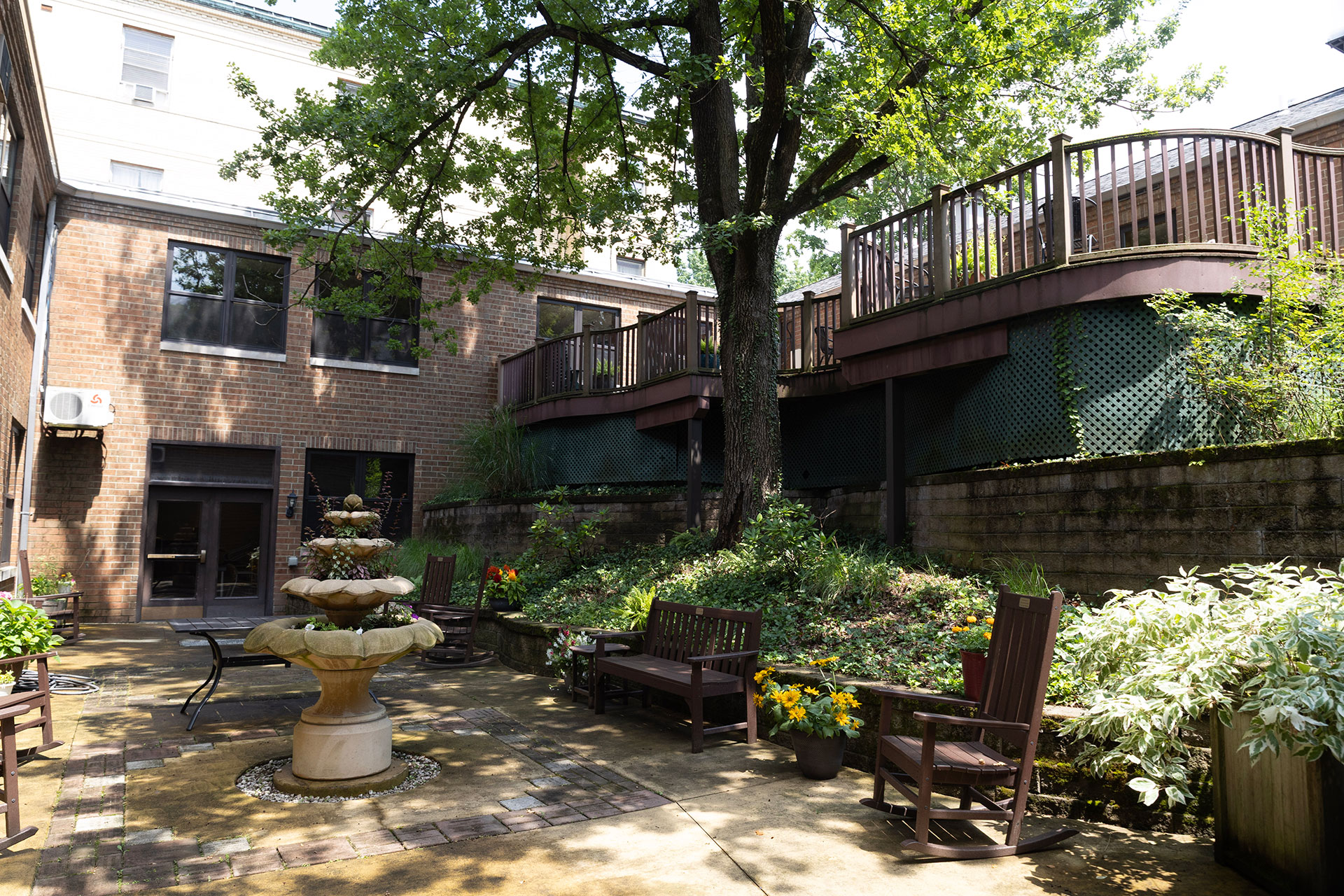 Quiet courtyard with fountain, seating, and greenery.