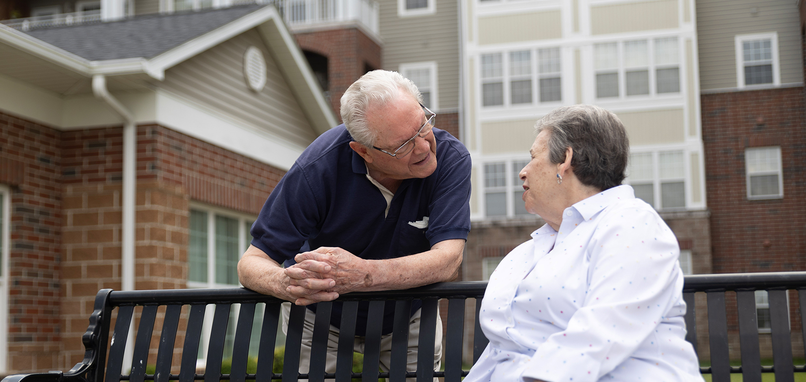 An elderly couple sharing a moment on a bench.