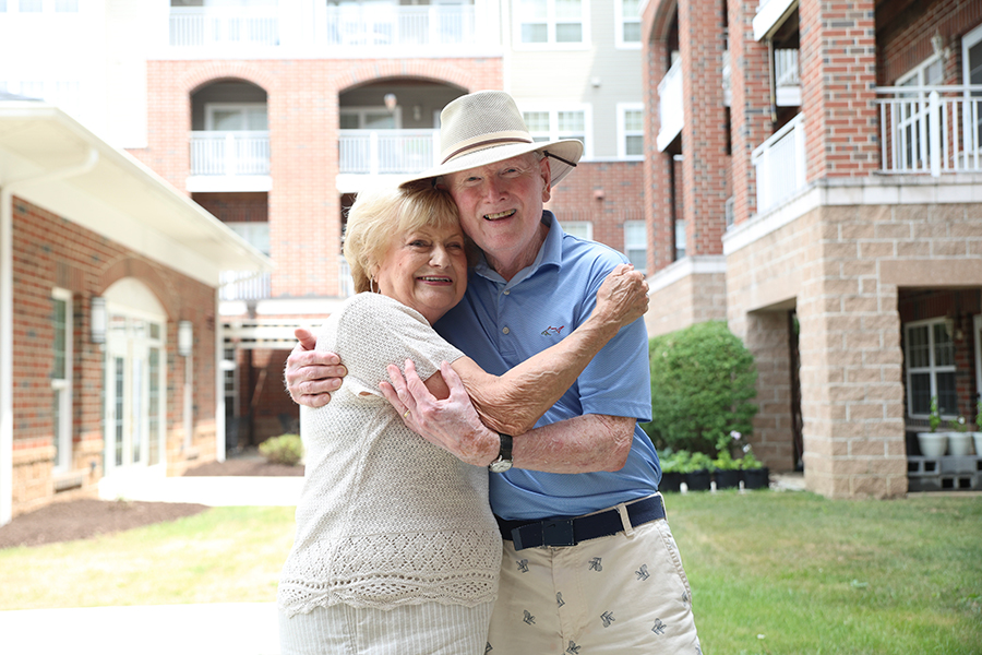 Happy elderly couple embracing outdoors.