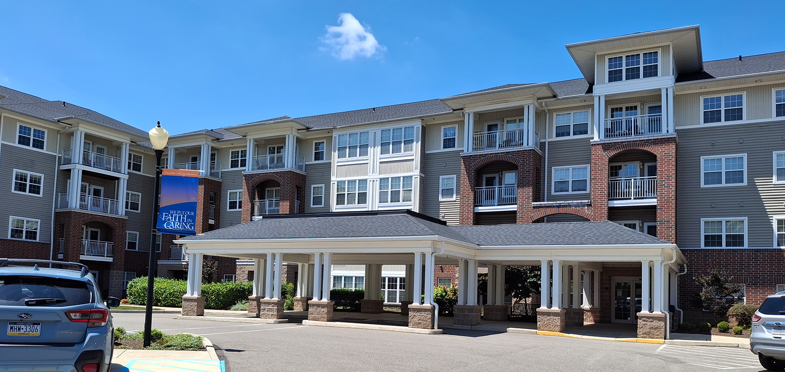 Residential building with awning and banner, clear blue sky.