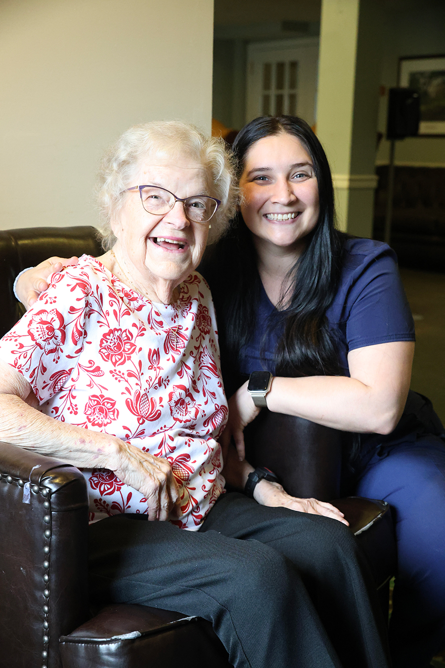 Two smiling women sitting together in a cozy setting.