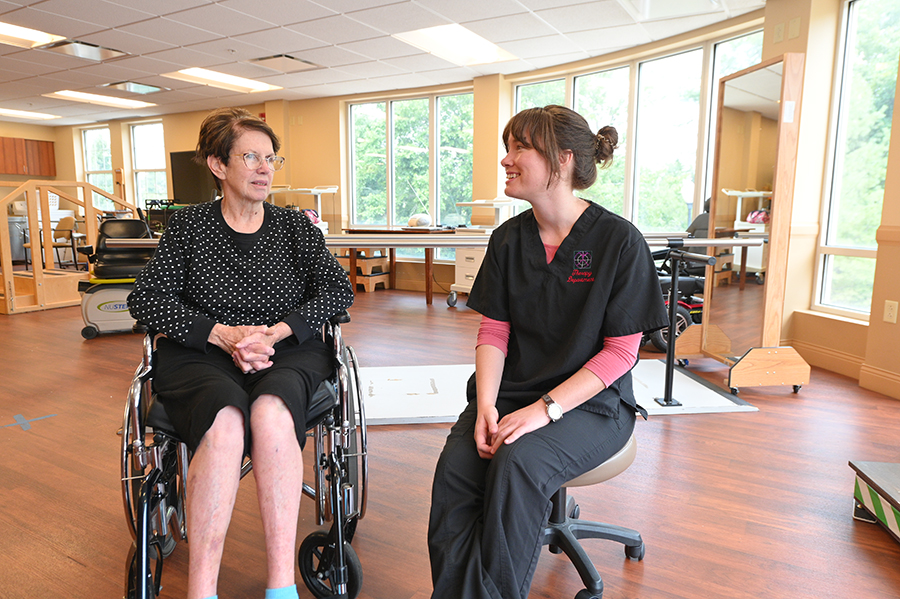 A therapist and a patient converse in a rehabilitation center.