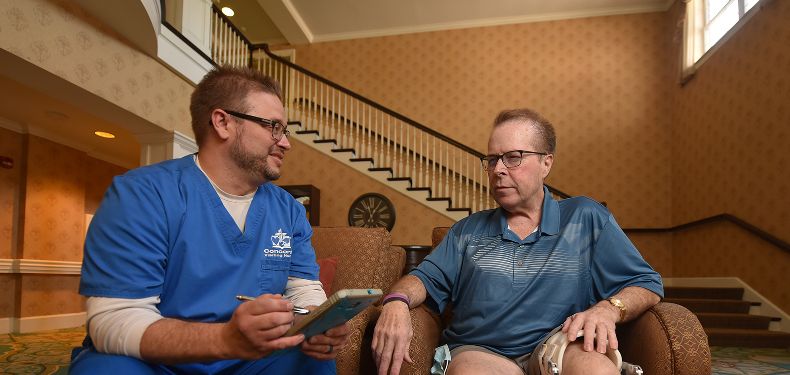 A healthcare worker consults with a patient in a cozy setting.
