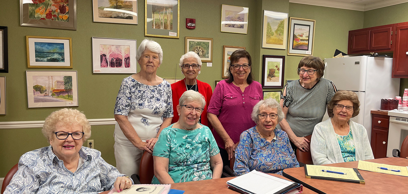 Group of smiling women in an artsy room.